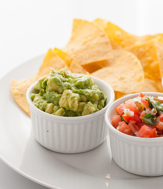 bowl of guacamole bowl of tomatoes and some tortilla chips