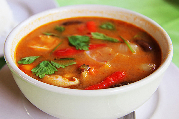 bowl of red soup with basil leaves