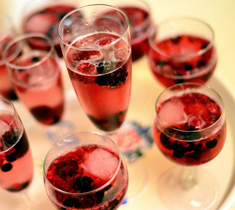 several glasses of red drinks with berries 