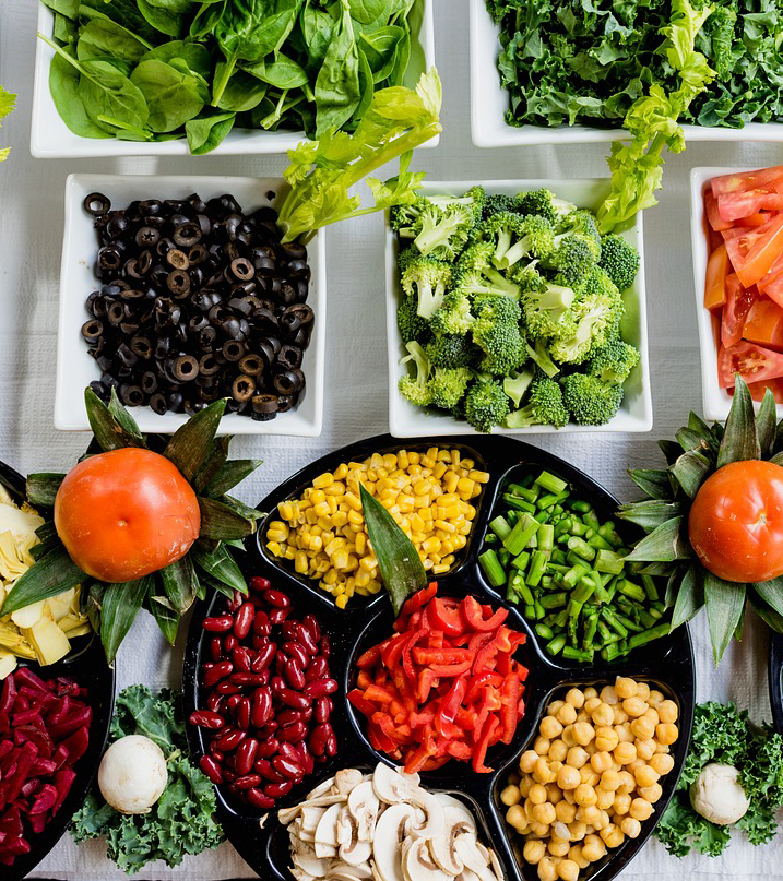several bowls of salads and vegetables at buffet