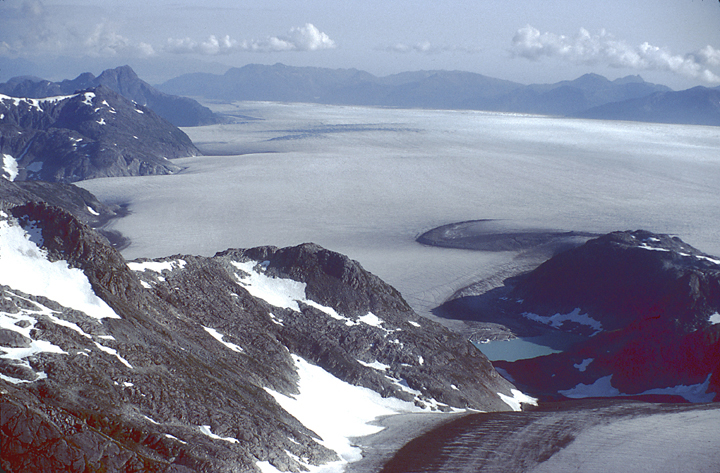 aerial in alaska of icefield surrounded by mountains