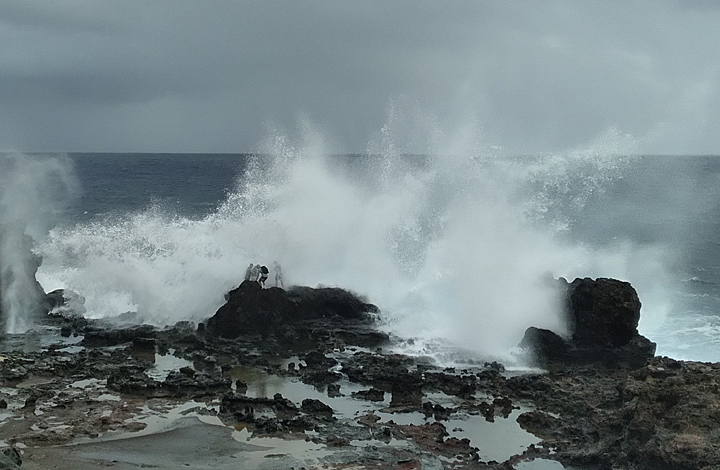 People getting splashed by a huge wave on maui Nakalele Blowhole