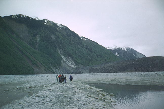 Lituya glacier with people walking on delta in front