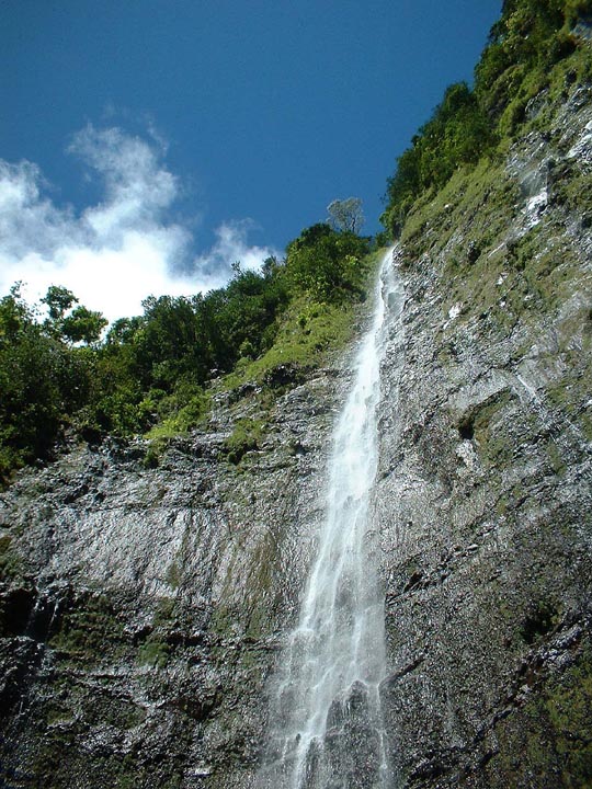 Looking up at tall white water falls 