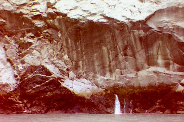 waterfall appearing out of just a crack in a rock wall