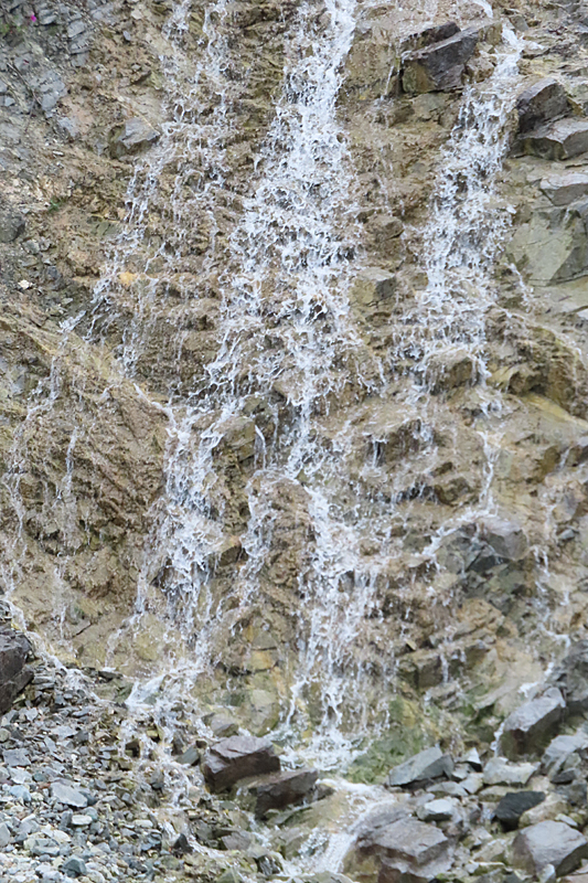 waterfalling down a brown rock face looks like lace